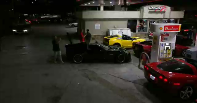 A nighttime gas station with a row of exotics — red C7 Corvette, white C8, and a Lamborghini among other cars — at an HTX Corvettes meet. A nighttime gas station with a row of exotics — red C7 Corvette, white C8, and a Lamborghini among other cars — at an HTX Corvettes meet.